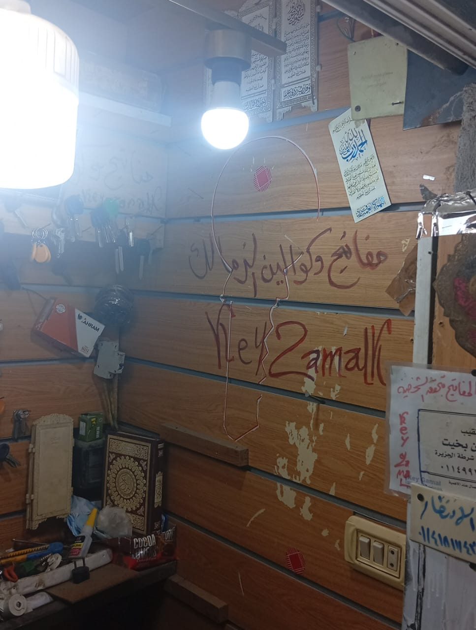 لافتة يدوية قديمة داخل المحل مكتوب عليها مفاتيح وكوالين الزمالك