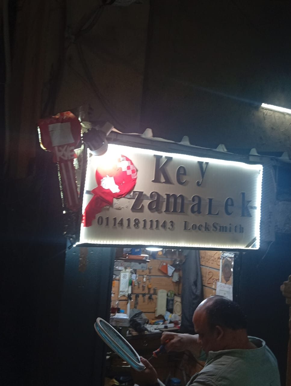 لافتة محل KEY ZAMALEK مضاءة ليلاً في شارع يحيى إبراهيم بالزمالك، برقم الطوارئ 01141811143